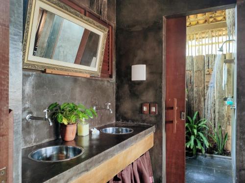 a bathroom with two sinks and a mirror at Convento Arcádia in Atins