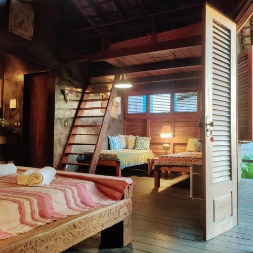 a bedroom with two beds and a spiral staircase at Convento Arcádia in Atins