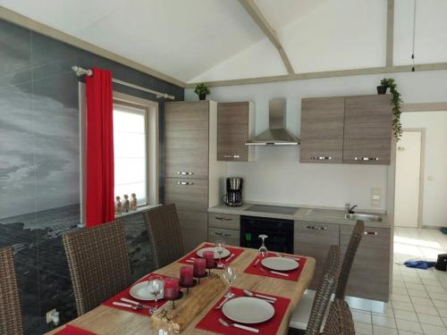 uma cozinha com uma mesa de madeira com guardanapos vermelhos em The Lighthouse em Middelkerke
