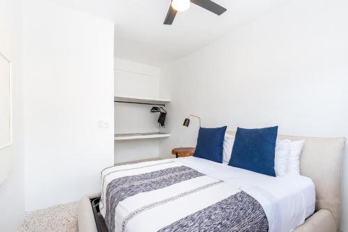 a bedroom with a large bed with blue pillows at Cuale in Puerto Vallarta