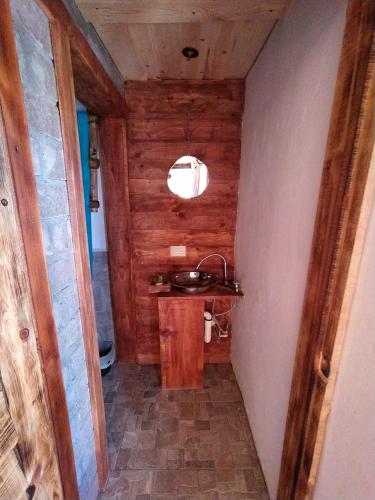 uma casa de banho com um lavatório e uma parede de madeira em Habitaciónes estilo cabaña las Herraduras em Creel