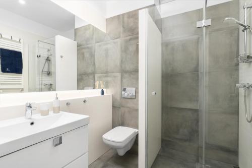 a bathroom with a toilet and a sink and a shower at Apartament MorSky Gardenia Dziwnów in Dziwnów