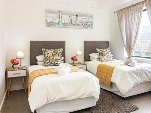 a bedroom with two beds with white sheets at East Point in Durban