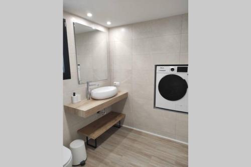uma casa de banho com um lavatório e um espelho em Precioso apartamento en una villa con piscina en Cumbre del Sol Moraira Benitachell em Cumbre del Sol