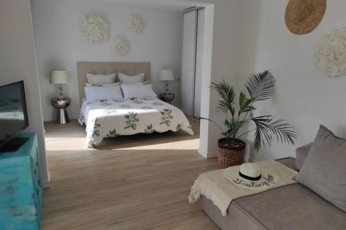 um quarto branco com uma cama e um sofá em Precioso apartamento en una villa con piscina en Cumbre del Sol Moraira Benitachell em Cumbre del Sol