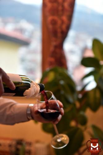 a person pouring wine into a wine glass at HANI I VJETER Boutique Hotel in Prizren