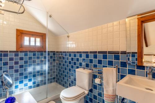 een blauw betegelde badkamer met een toilet en een wastafel bij Villa Tabua in Ribeira Brava