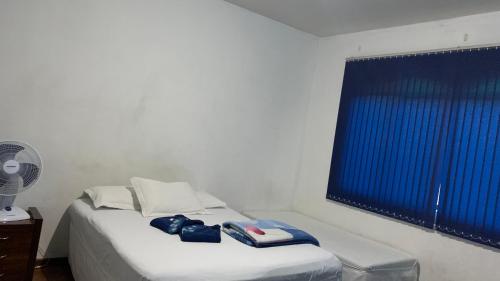 En eller flere senge i et værelse på Hostel Assis Divinópolis