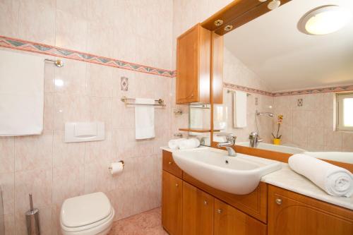 łazienka z umywalką, toaletą i lustrem w obiekcie Villa Sveta Eufemija - Bed and breakfast w Rovinj