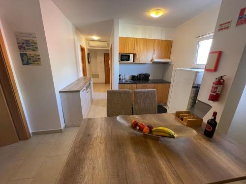 a kitchen with a table with a bowl of fruit on it at Esmeralda Holidays Apartments in Funchal