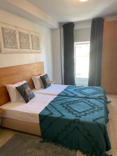 a bedroom with a large bed and a window at Esmeralda Holidays Apartments in Funchal