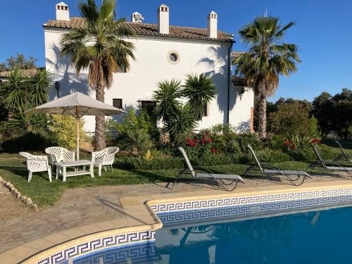 eine Villa mit einem Pool und einem Haus in der Unterkunft Finca las Encinas in Ronda