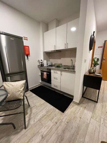 a small kitchen with white cabinets and a refrigerator at Esmeralda Holidays Apartments in Funchal
