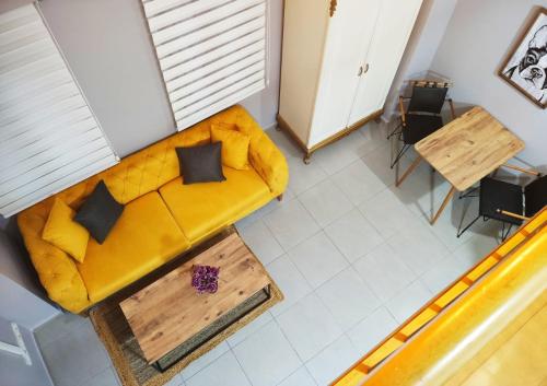 uma sala de estar com um sofá amarelo e uma mesa em Cozy Duplex House-Near Taksim-Home Design em Istambul