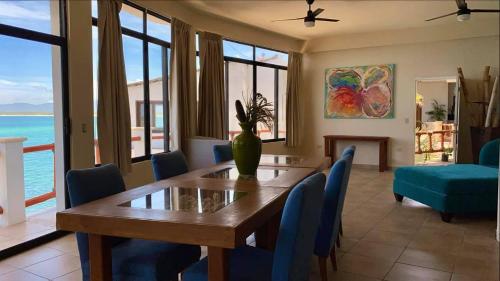 a dining room with a table and chairs and the ocean at Villa Paraíso in La Ventana
