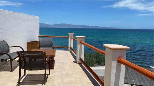 a balcony with chairs and a table and the ocean at Villa Paraíso in La Ventana