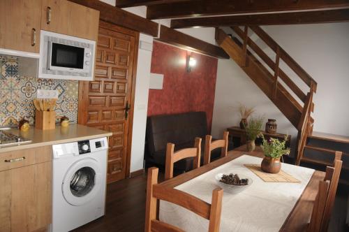 a kitchen and dining room with a table and a washing machine at EL VASALLO 2 in Tragacete