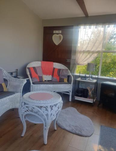 a living room with two chairs and a table at Broadlea of Robgill Country Cottage Accommodation in Ecclefechan