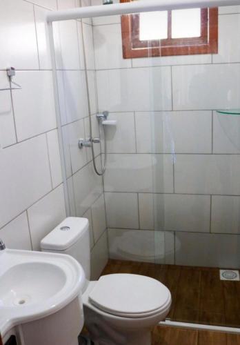 a bathroom with a shower and a toilet and a sink at Império Cabanas in Urubici