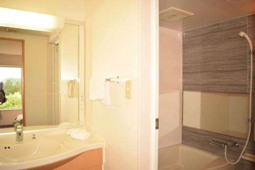 a white bathroom with a sink and a shower at Kagetsuen in Hakone