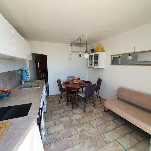 a kitchen and dining room with a table and chairs at A Casarella in Lumio