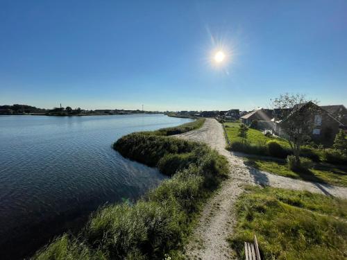 a view of a river with the sun in the sky at Wangerbrise in Wangerland