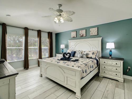 a bedroom with a white bed and blue walls at Luxury Family Villa Pool Hot Tub Close to Disney in Orlando