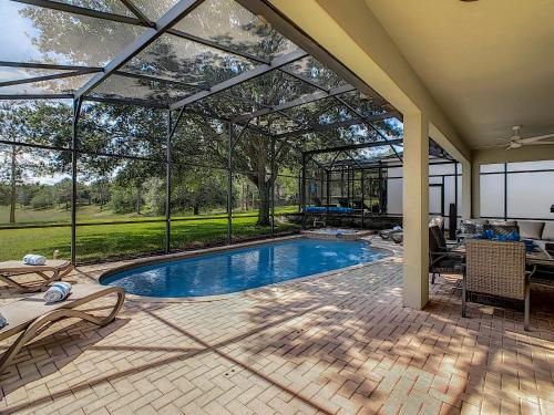 a swimming pool in a house with a glass extension at Luxury Family Villa Pool Hot Tub Close to Disney in Orlando