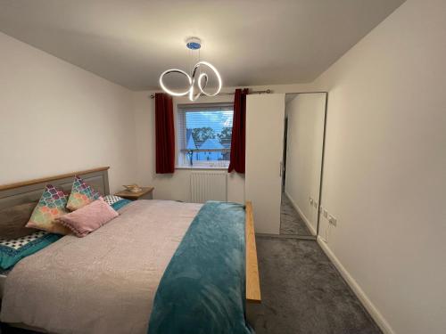 een slaapkamer met een groot bed en een kroonluchter bij White house in Milton Keynes