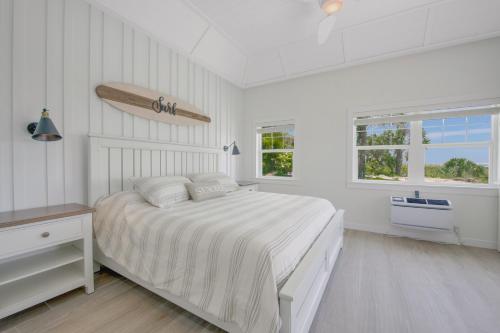 a white bedroom with a bed and two windows at Casey Key Resorts - Beachfront in Venice