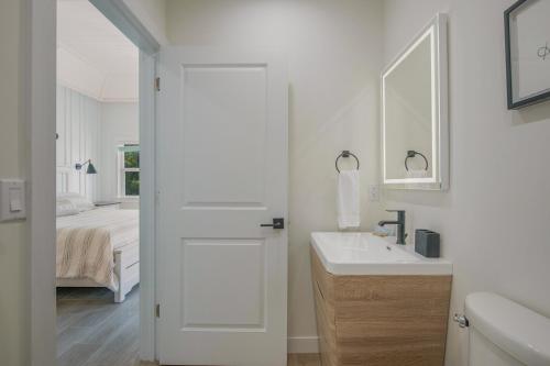 Baño blanco con lavabo y espejo en Casey Key Resorts - Beachfront, en Venice