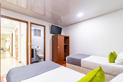 una camera d'albergo con due letti e una televisione di Hotel Harrington 63 a Bogotá
