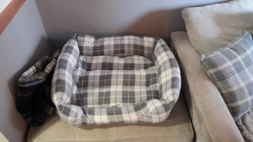 a plaid pillow sitting on top of a couch at Cosy Georgian Cottage in the Heart of Bewdley, Worcestershire in Bewdley