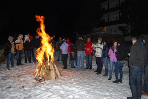 a group of people standing around a large fire at Conacul Ursului in Cumpăna