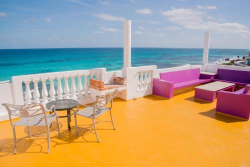 a balcony with a table and chairs and the ocean at Villa Elena Isla Mujeres in Isla Mujeres
