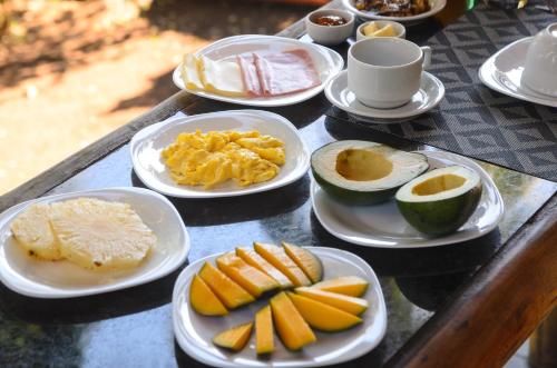 a table with plates of breakfast foods on it at Fauna in Praia do Bananal