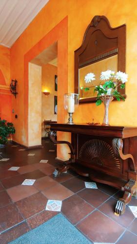 a room with a table with a mirror and flowers on it at Hotel Boutique Casa Montalvo Cuenca in Cuenca
