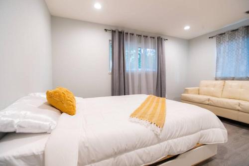 ein Schlafzimmer mit einem weißen Bett und einem Sofa in der Unterkunft Spacious 5 Bedroom Home! Free WIFI! AC & HEAT! in San Jose