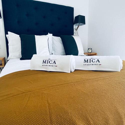a bed with two pillows on top of it at Mica Apartments in Sere Kunda