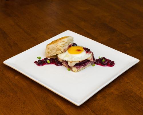 a white plate with an egg and a sandwich on a table at The Inn on First in Napa