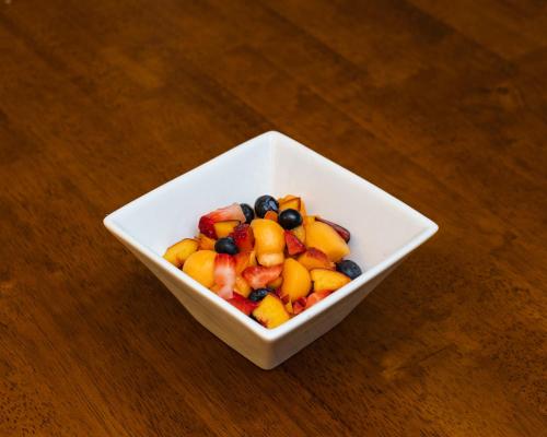 a white bowl filled with fruit on a wooden table at The Inn on First in Napa