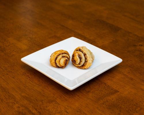 two donuts sitting on a white plate on a table at The Inn on First in Napa
