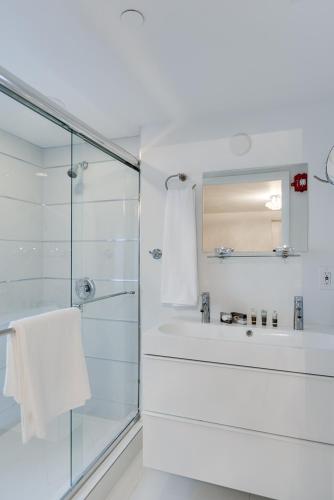 a white bathroom with a shower and a sink at Bars B&B South Beach Hotel in Miami Beach