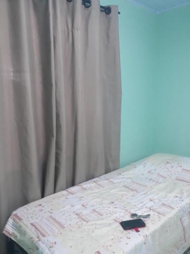 - un lit avec un rideau blanc à côté d'une fenêtre dans l'établissement Pousada vithoria, à Pinhais