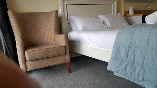 a bedroom with a bed and a chair next to a bed at Alpine Chalets in National Park