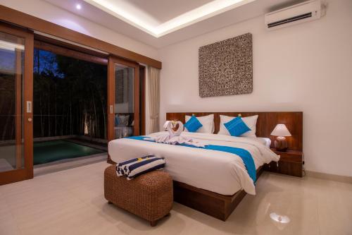 een slaapkamer met twee bedden en een groot raam bij Villa Sayang Sanur IV in Sanur