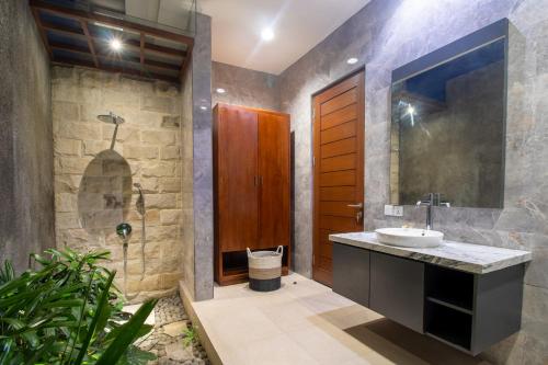 ein Bad mit einem Waschbecken und einer Dusche in der Unterkunft Villa Sayang Sanur IV in Sanur