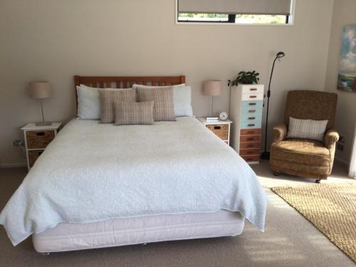 
a bedroom with a white bedspread and white pillows at Abel Tasman Sands BnB in Marahau
