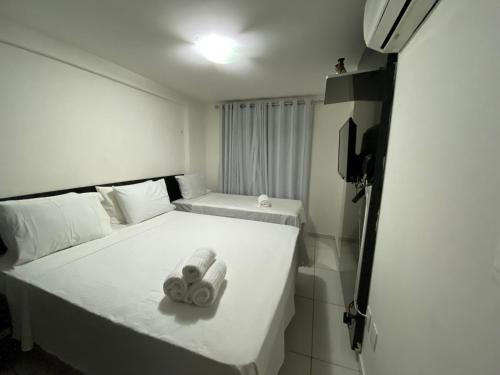 a bedroom with a bed with two towels on it at Israel Flat Tambaú in João Pessoa