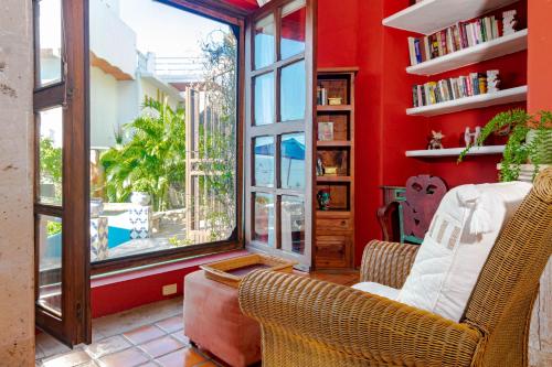 a living room with red walls and a large window at Villas Jardin Del Mar in Cruz de Huanacaxtle